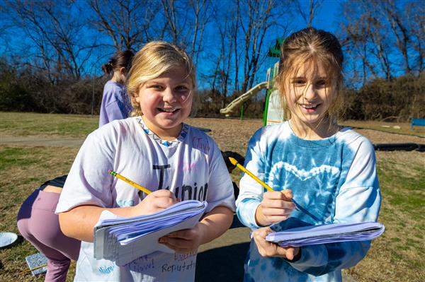 two girls smiling with notebooks
